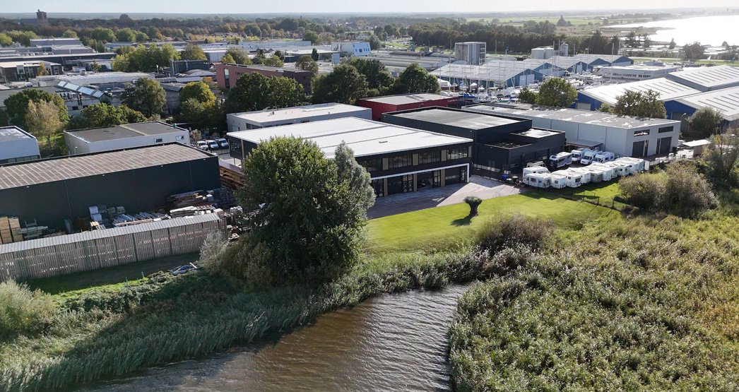 Impressie van een moderne bedrijfsruimte in Elburg met kantoorvoorzieningen, opslagruimte en een groene omgeving aan het water